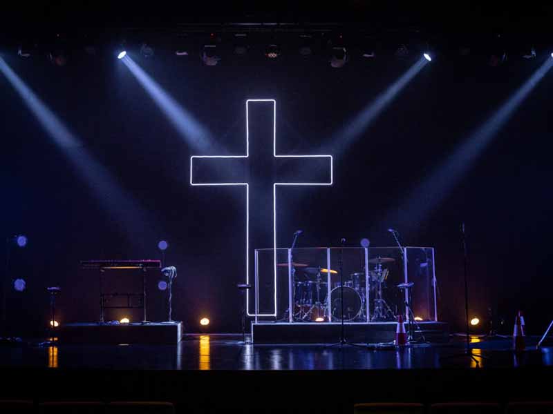 Pengaturan panggung gereja yang mudah dengan salib menyala LED sebagai latar belakang